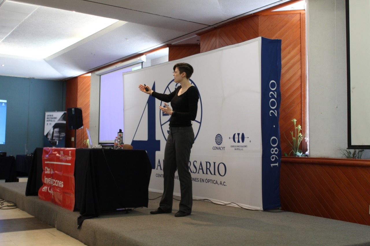 Dr. Willis stands on a stage wearing black and delivering a workshop, gesturing expansively with her hands.